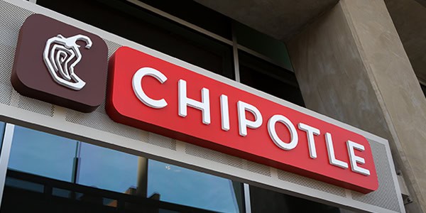 Exterior signage for Chipotle with the brand’s red and white logo mounted on a building, featuring the signature pepper icon.