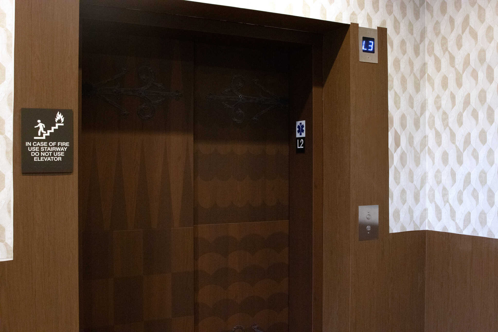 Elevator doors at Epic’s headquarters wrapped in dark wood graphics with wrought-iron-style embellishments, blending into the interior decor.