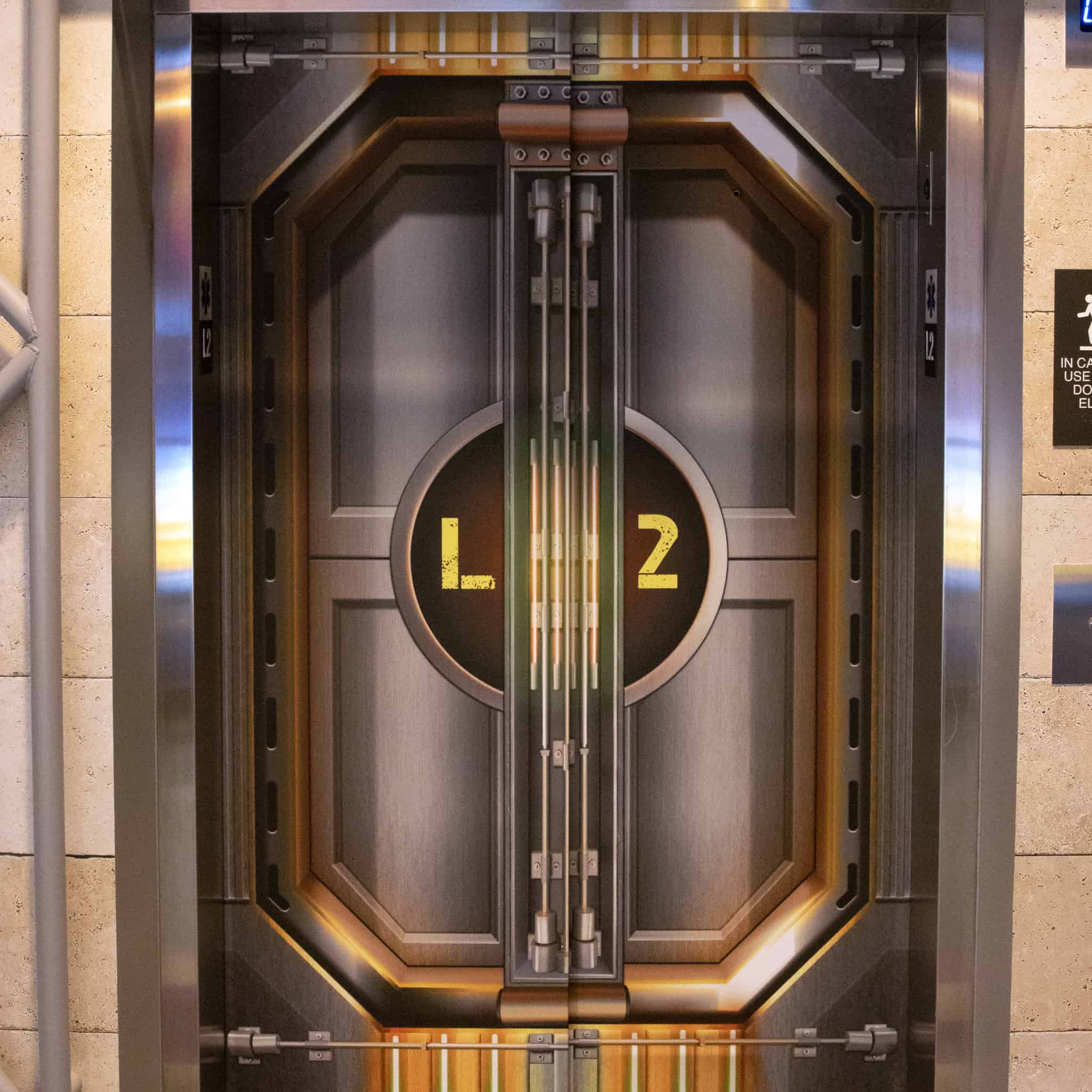 Elevator doors at Epic’s headquarters in Verona, WI, wrapped in sci-fi themed graphics featuring industrial paneling and the label “L2.”