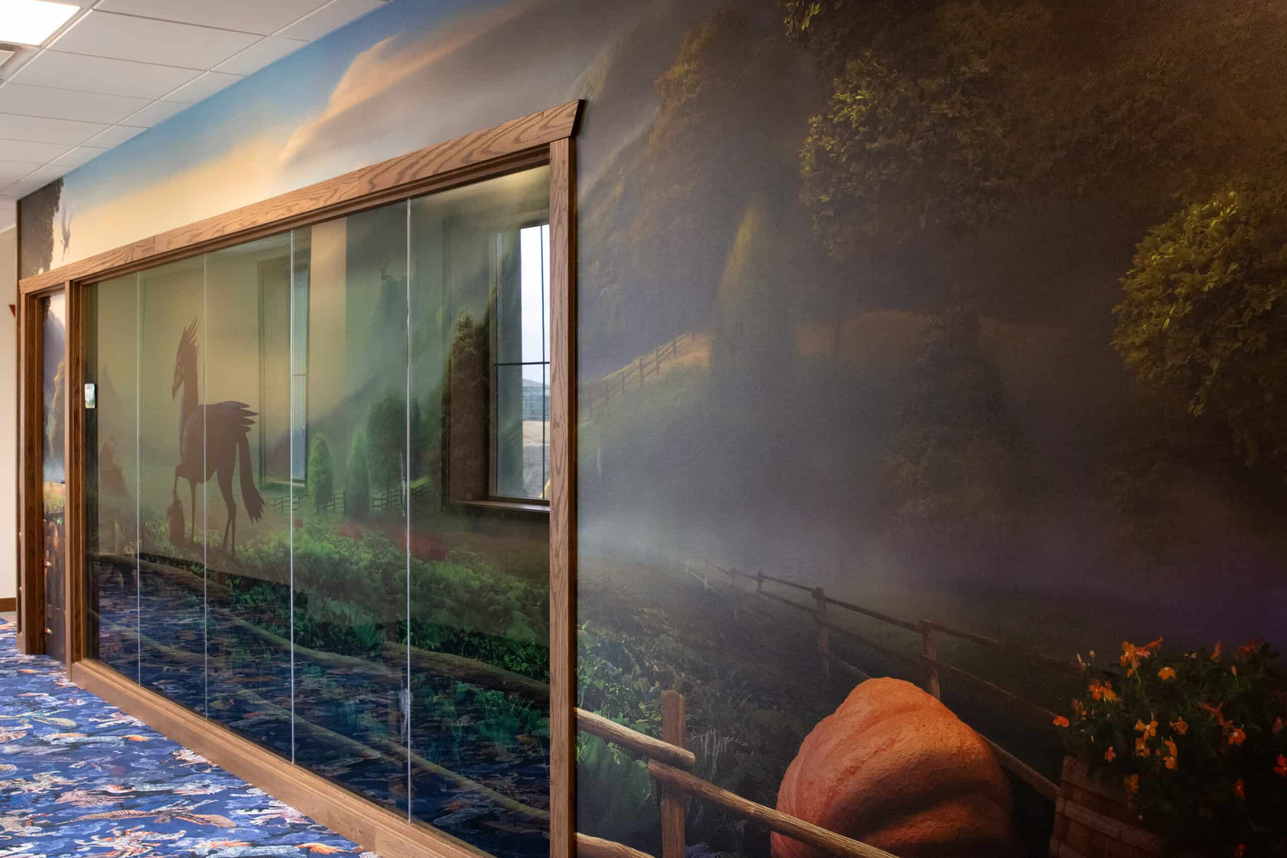 A fairytale-inspired conference room wrapped in a misty mural of farmland with oversized pumpkins, wooden fences, and a silhouetted horse carrying a basket through a dreamy landscape.