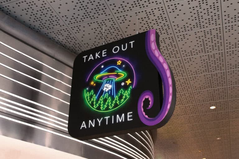 Dimensional overhead sign that reads “TAKE OUT ANYTIME” with a neon-style UFO abducting a cow, accented by a purple tentacle shape.