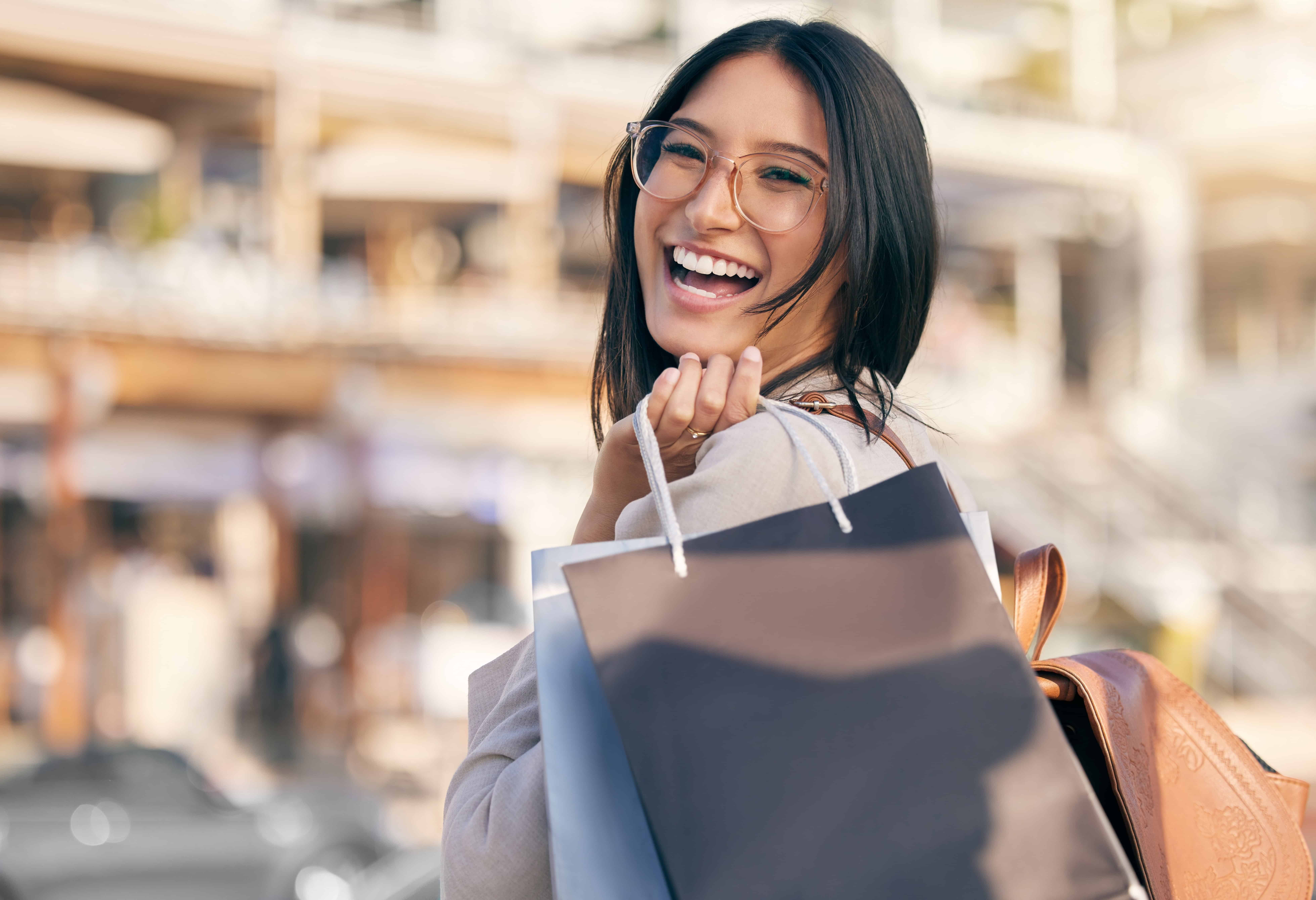 Shopping, bag and portrait of woman in city excited for discount sale, promotion or luxury boutique. Laughing, girl and customer with retail deal and purchase clothes or fashion at store in New York