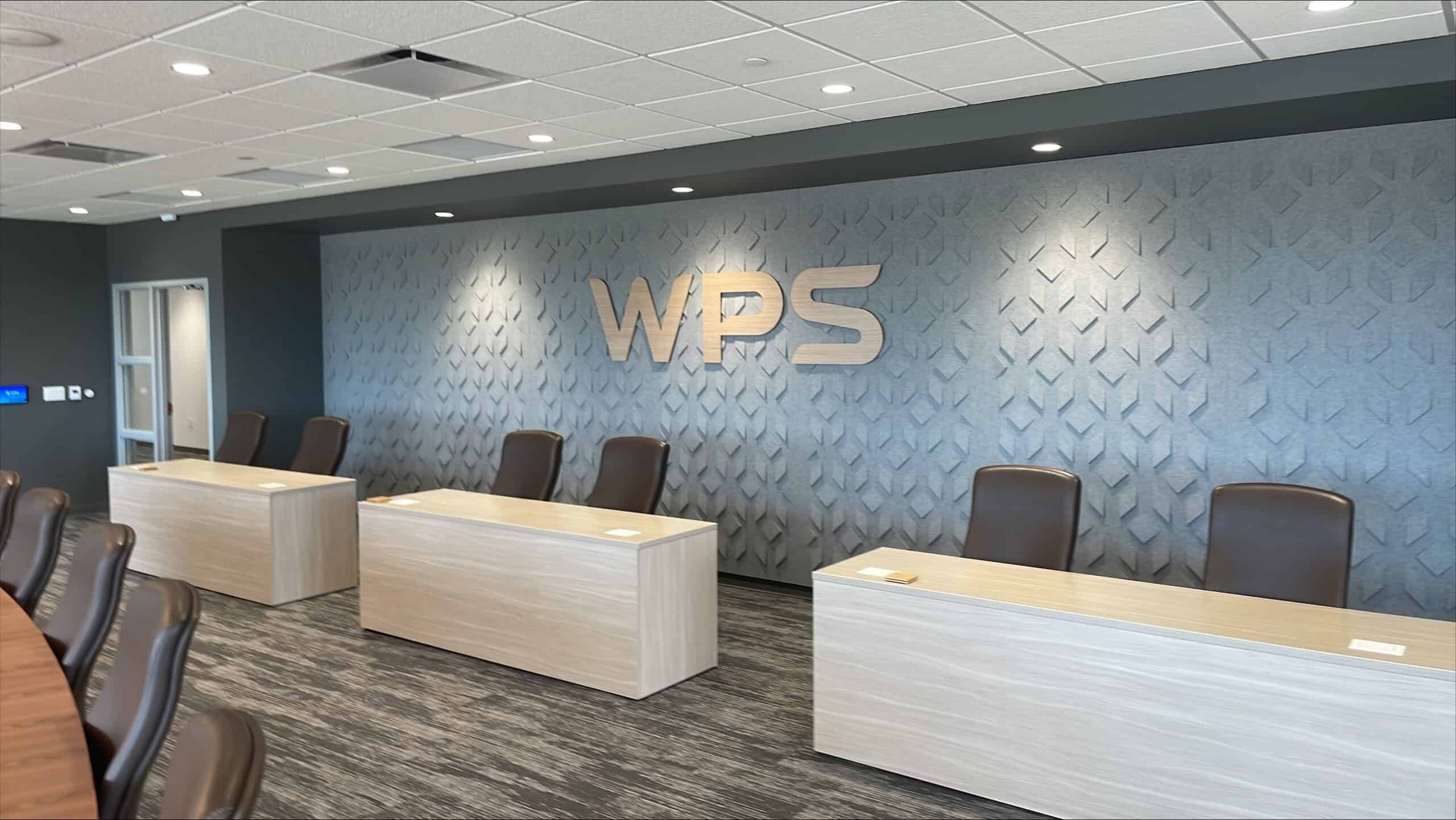 Executive boardroom wall at WPS headquarters featuring dimensional wood WPS letters on textured geometric panel backdrop.