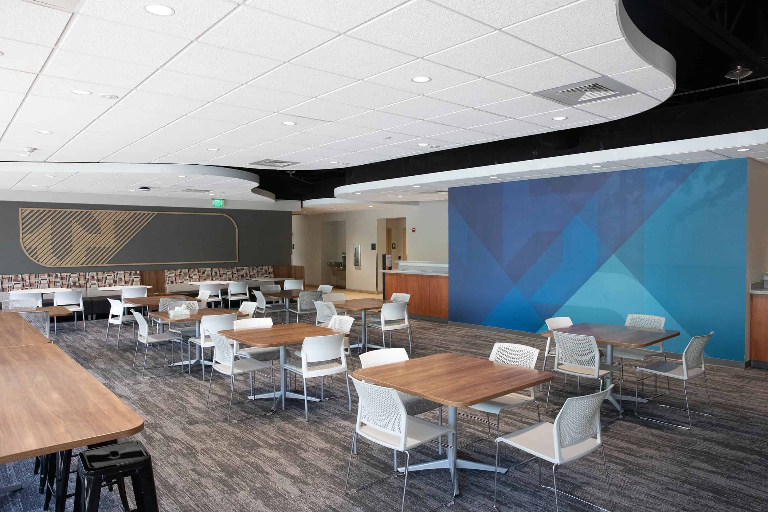 Wide view of WPS cafeteria with branded wood slat art and blue feature wall.
