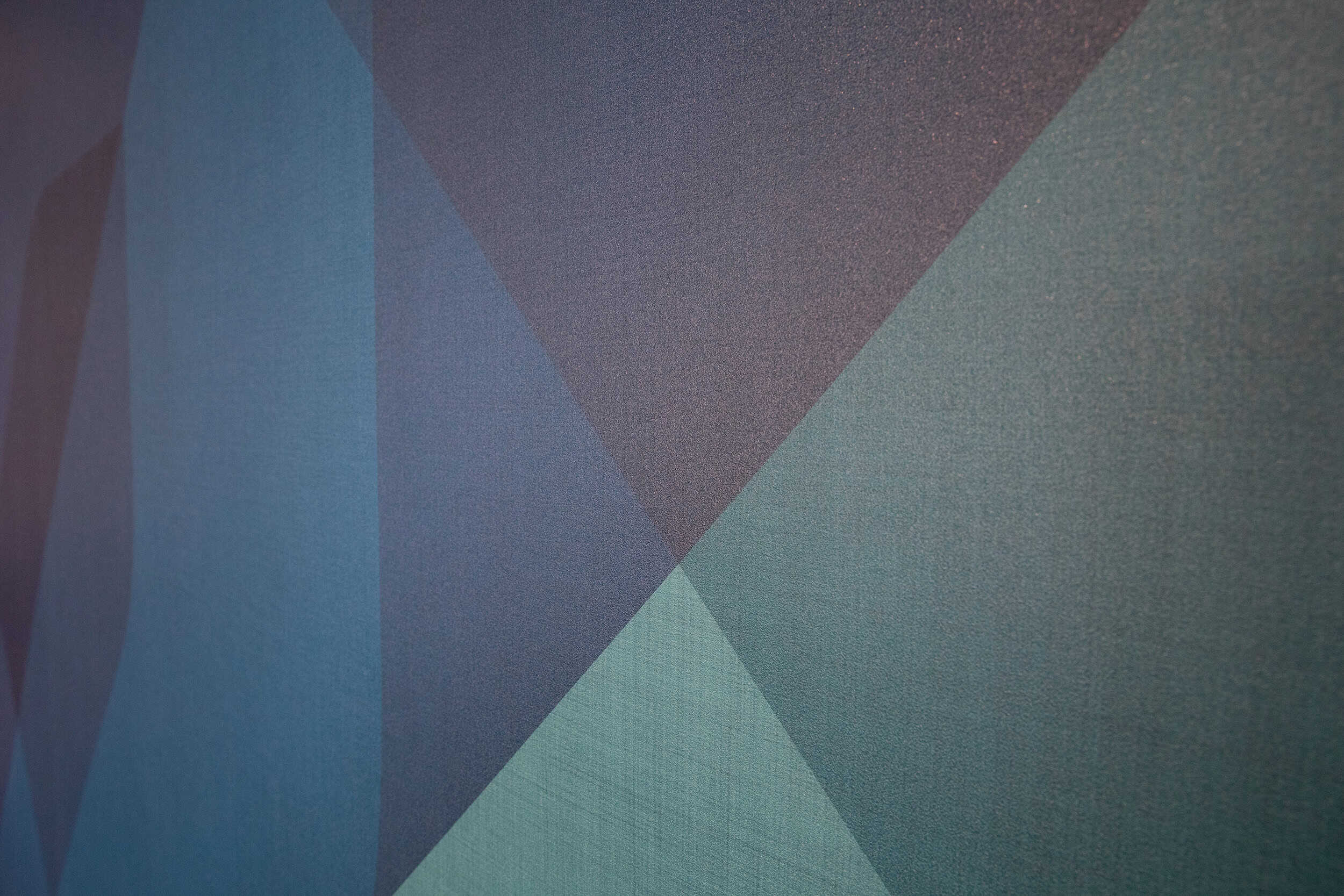 Close-up of textured wall graphic at WPS headquarters featuring geometric blue brand pattern.
