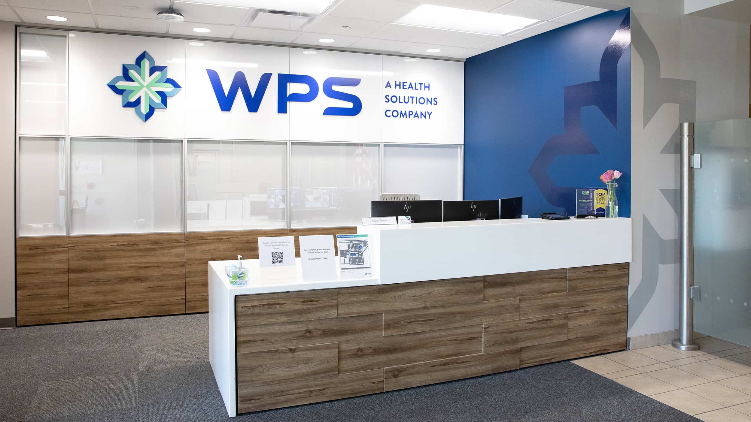Reception desk and branded wall with WPS Health Solutions logo at company headquarters.