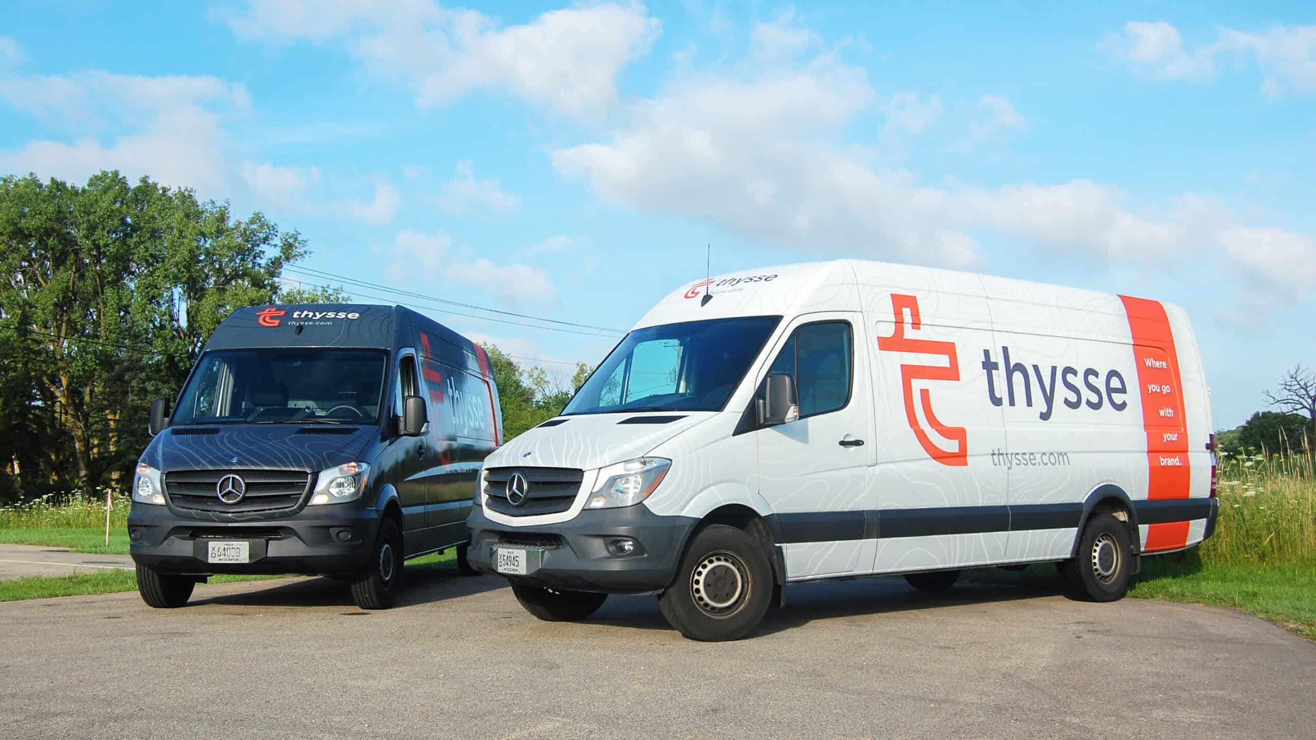 Two Thysse-branded Mercedes-Benz delivery vans parked outdoors, featuring the Thysse logo and tagline “Where you go with your brand.”