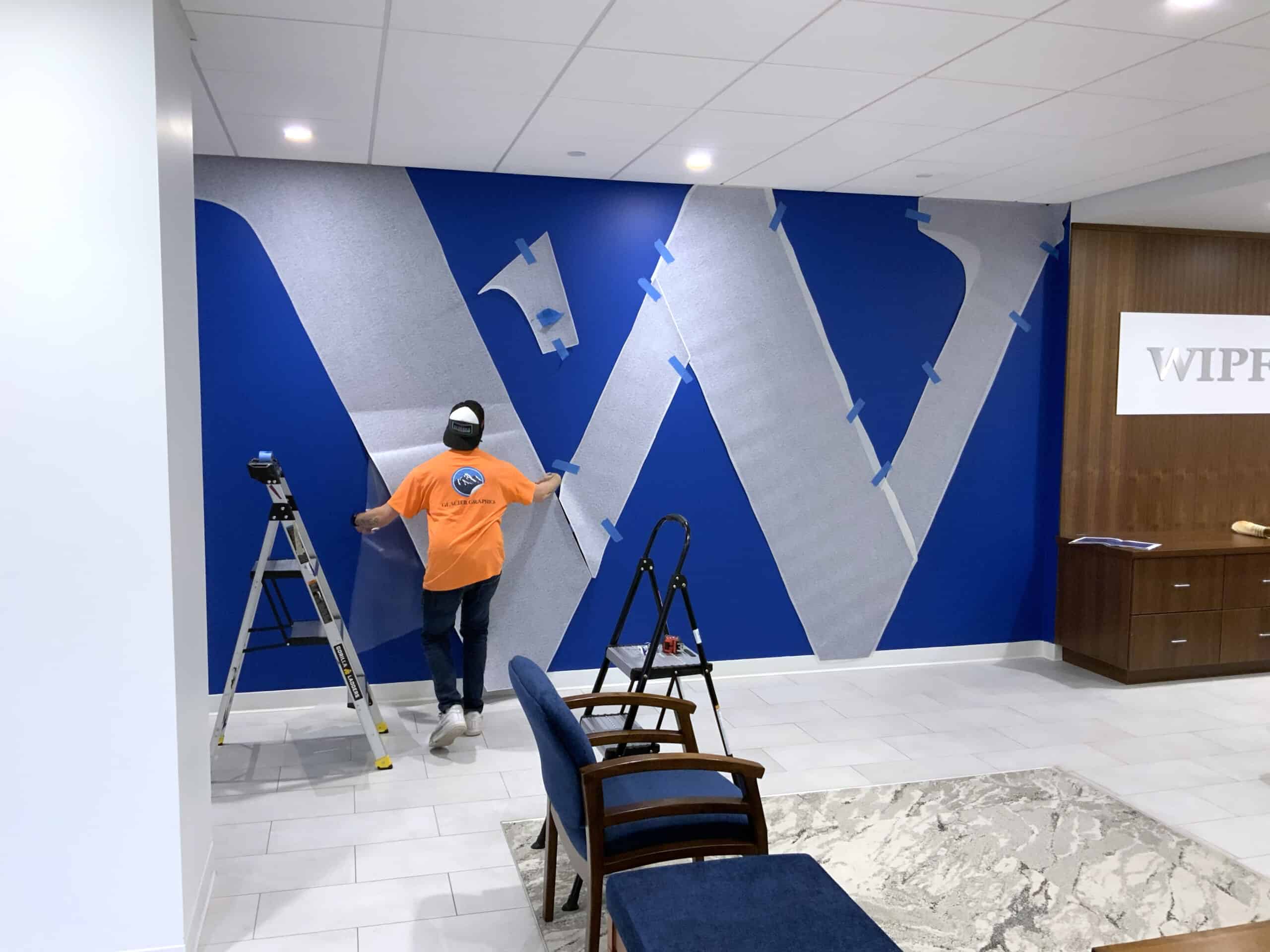 Installer Aligning Wall Vinyl Logo