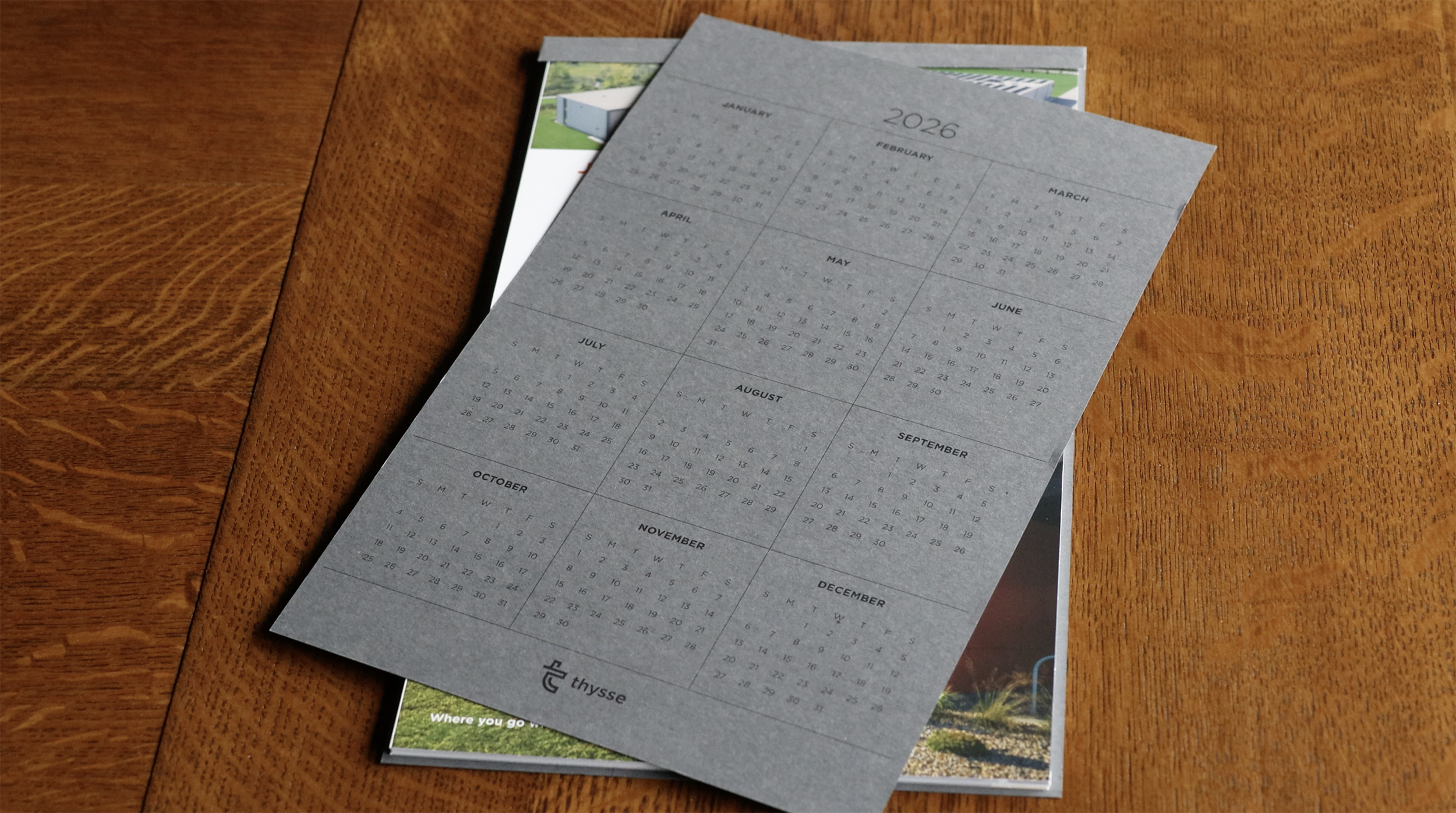 Loose 2026 year-at-a-glance sheet printed on gray stock, resting on top of the open calendar.