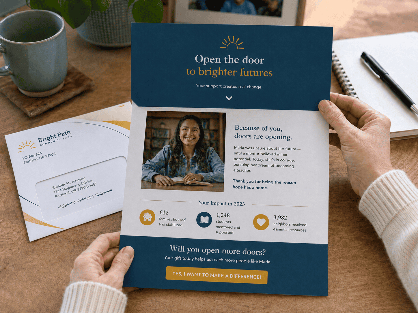 An interactive nonprofit fundraising self-mailer from Bright Path Community Fund is opened on a desk, revealing a donor story, impact statistics and a call to give, with a branded envelope beside it.
