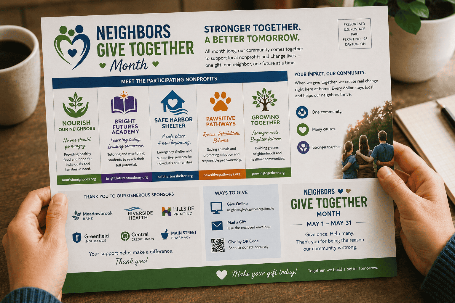 A person holding a Neighbors Give Together Month nonprofit self-mailer at a wooden table. The shared campaign mailpiece highlights several participating nonprofits, explains ways to give, recognizes local sponsors and encourages donations during a month-long community giving campaign.